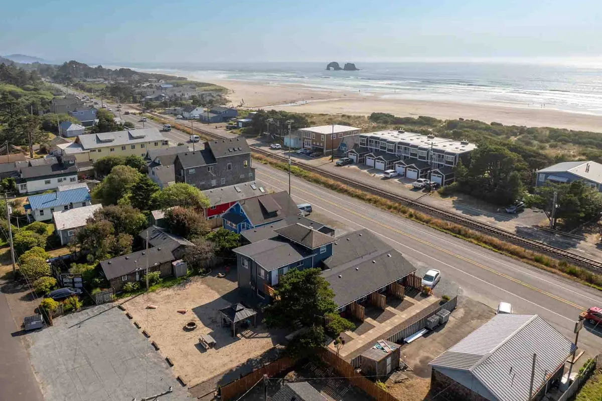 This exterior image displays a scenic view of the beach and ocean, with nearby homes and a road leading towards the shoreline. The open sands and gentle waves create an inviting environment for leisurely walks, beachcombing, and enjoying the outdoors.